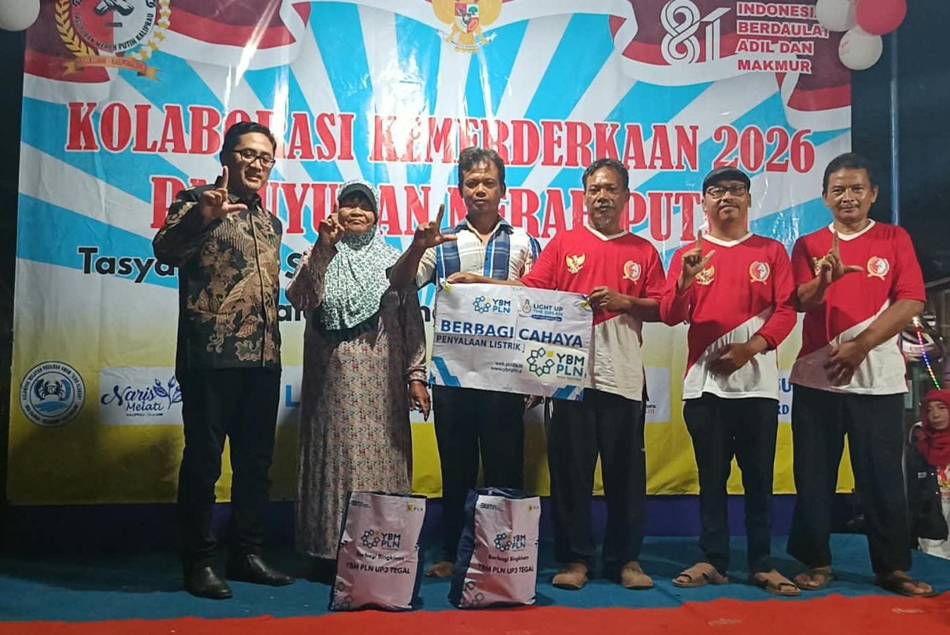 Manajer ULP PLN Comal Pemalang Sucipto Arief (batik kiri) menyerahkan bantuan pasang listrik gratis untuk warga kurang mampu di Desa Kaliprau didampingi pengurus Paguyuban Merah Putih